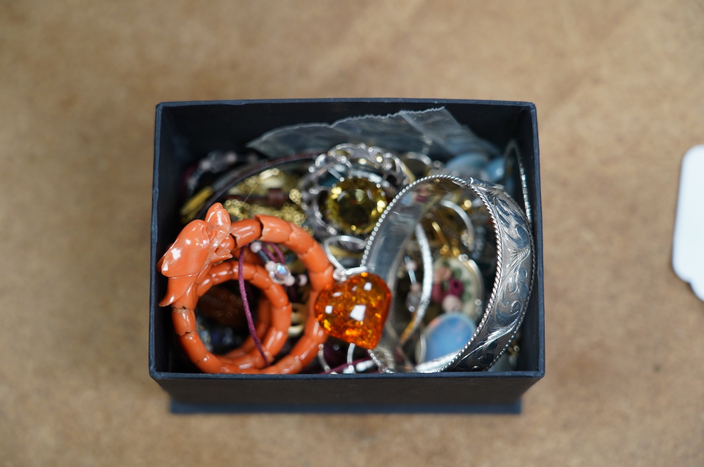 A small quantity of assorted jewellery including a coral set coiled dragon bracelet, a 1970's engraved silver hinged bangle, a Scottish silver and citrine brooch and costume. Condition - poor to fair to good